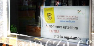 Cartel colocado en un escaparate de Gráficas Nino, en el que se ofrece el libro Capiteles I.