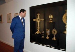 El encargado del Museo de Covadonga, Javier Remis, observa varias piezas, entre ellas un ostentorio en forma de cruz, de plata sobredorada con diamantes y perlas, donado en 1902 por Paz Blanco, viuda de Trelles. / RAMÓN DÍAZ